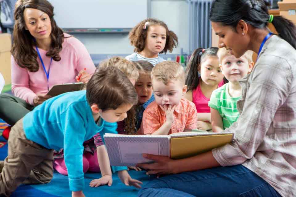 A teacher reads a story to schoolchildren.
