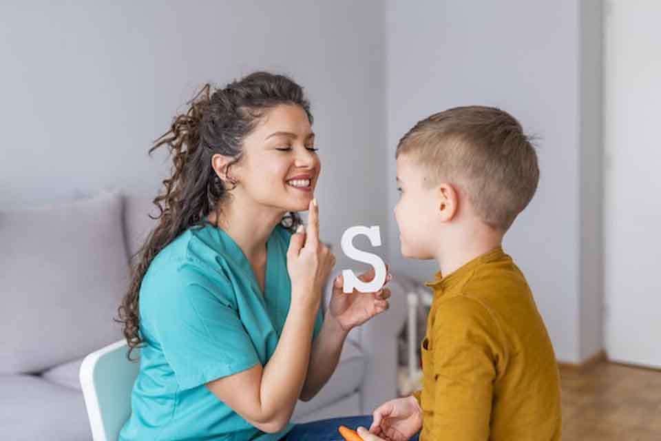 A speech pathologist works with a child.