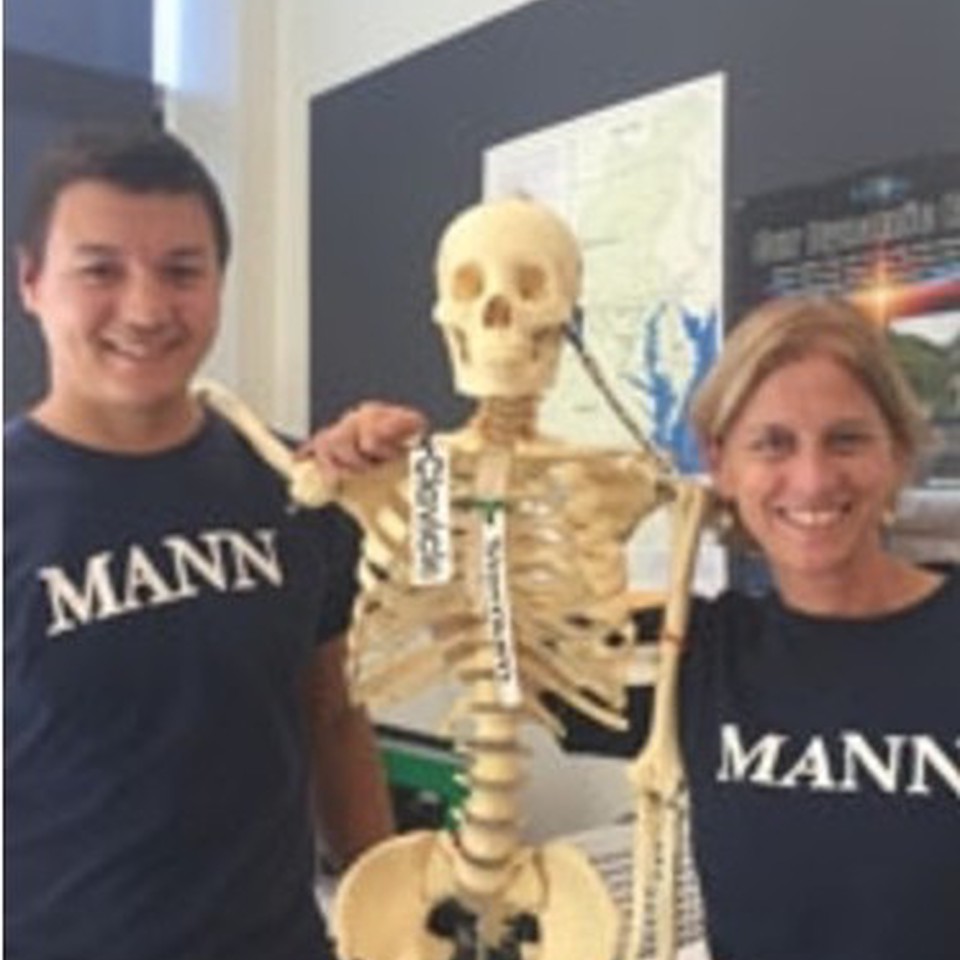 Students posing with a skeleton model for a project in their teaching degree program.