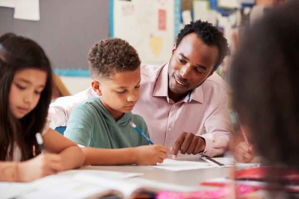 A teacher helps a student.