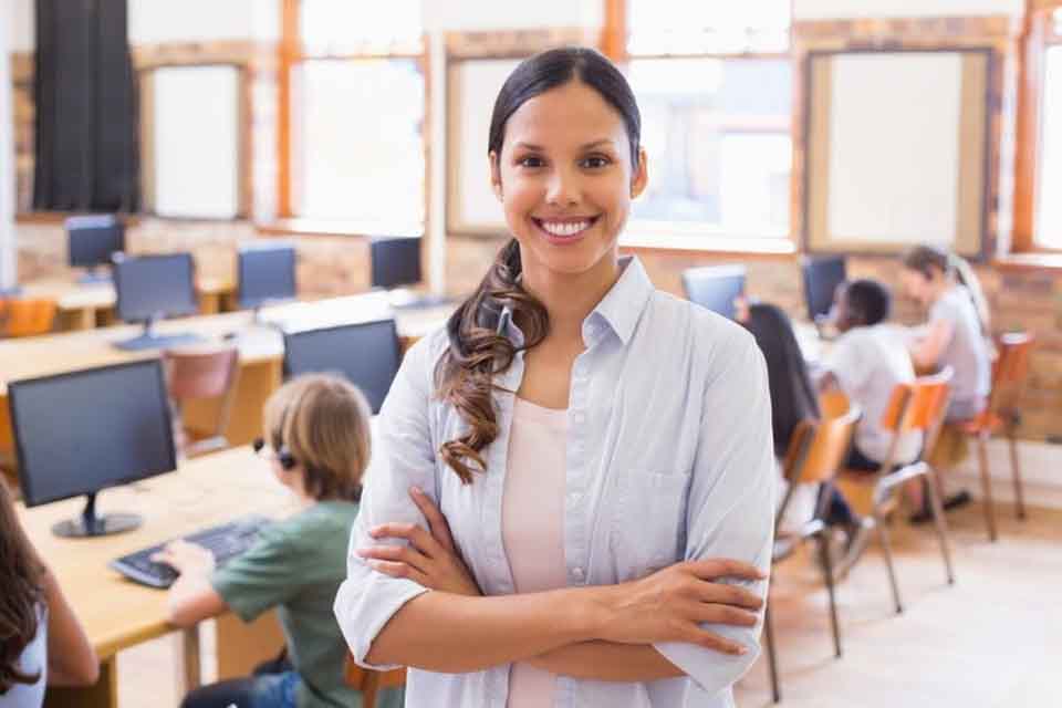 Smiling teacher standing in front of students.