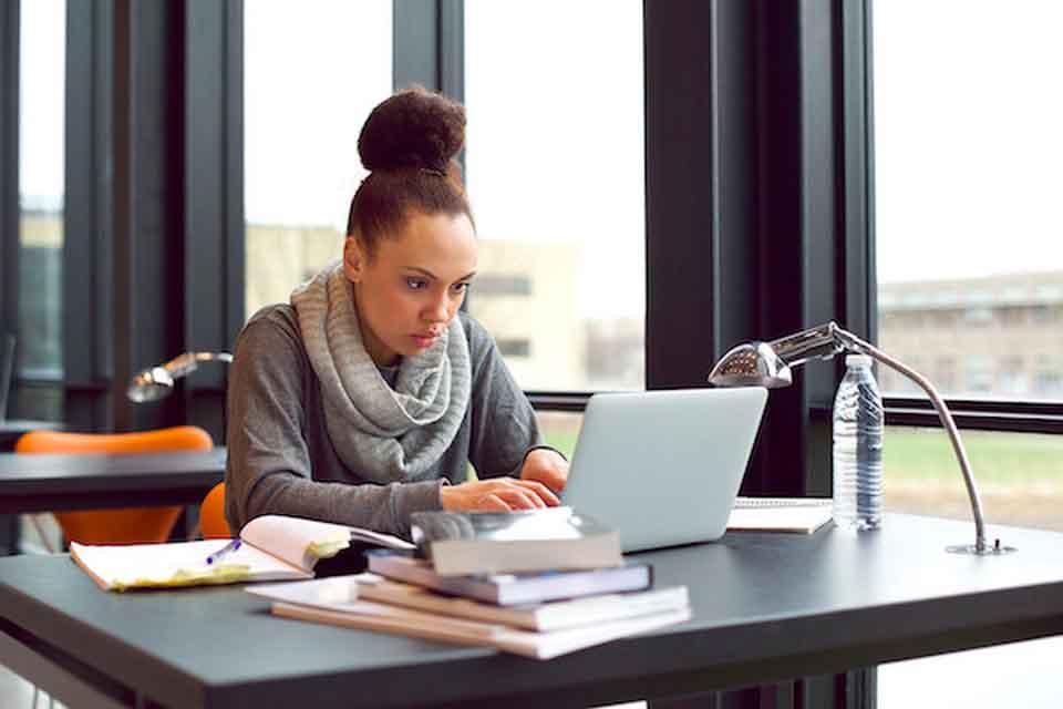 A woman looking at her laptop screen