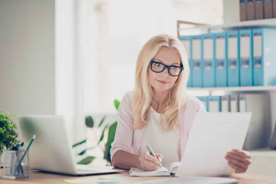 A principal reviews paperwork at her desk.