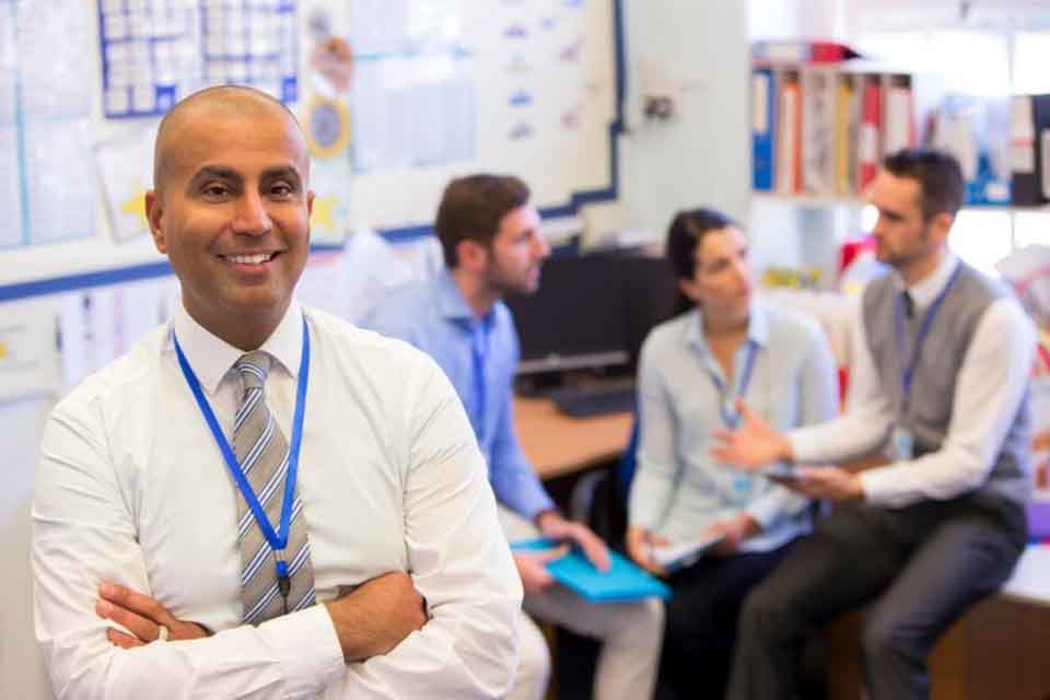 A school district administrator meets with staff in an office.