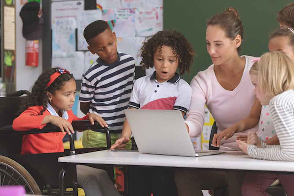 Teacher conducts a lesson with a diverse group of students.