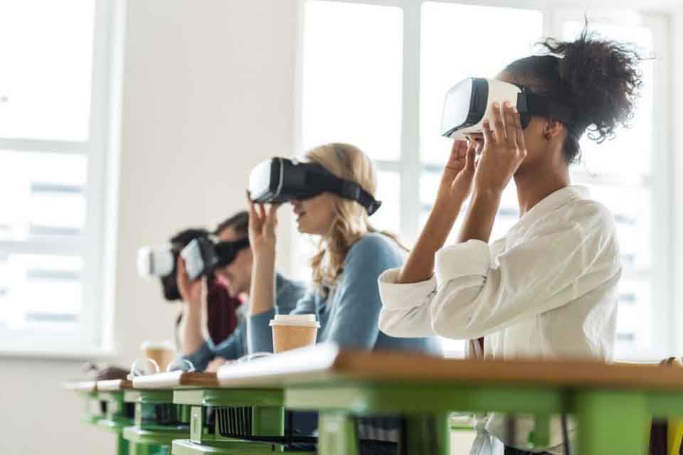 Students wearing VR headsets sit at desks in a classroom.
