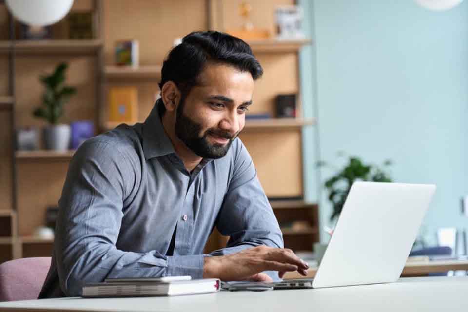 An instructional coordinator works at a laptop.