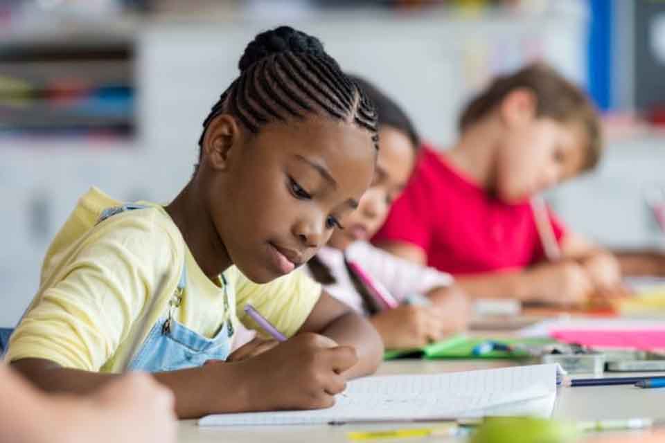 A girl writing on her notebook during class
