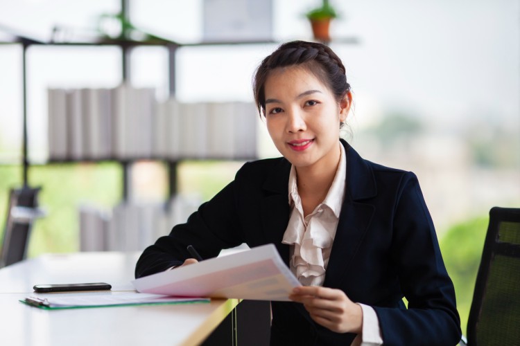 A higher education administrator looks at paperwork.