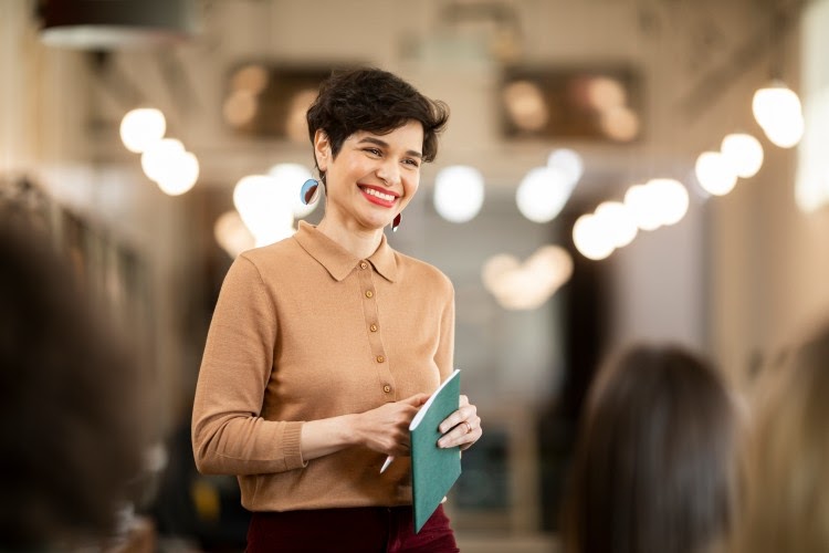 An education professional stands and smiles.