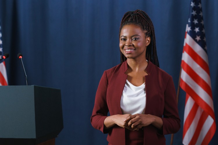 A government official smiles and stands near a podium.