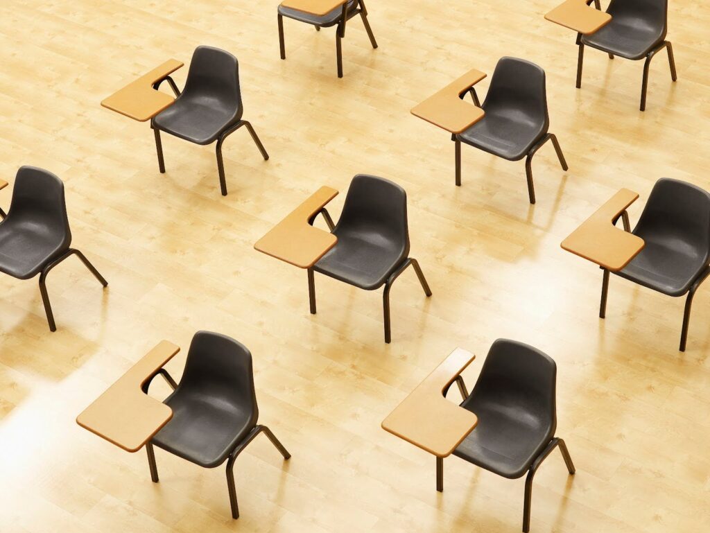 Student desks in an empty classroom, shot from a high angle.