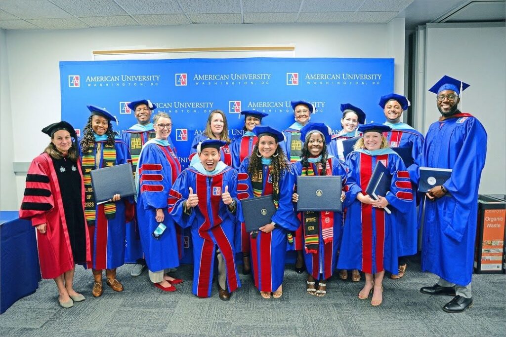 2023 ITEP graduates in cap and gown pose with their diplomas.